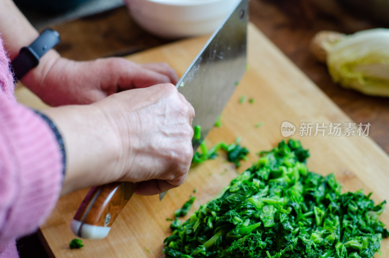 在木制切菜板上切绿色蔬菜