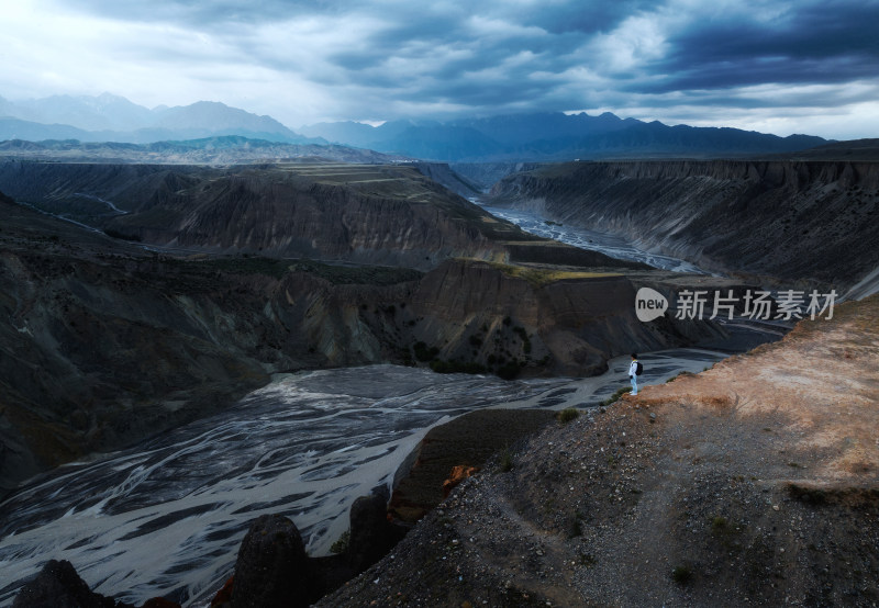 航拍男子站在新疆安集海峡谷的悬崖边