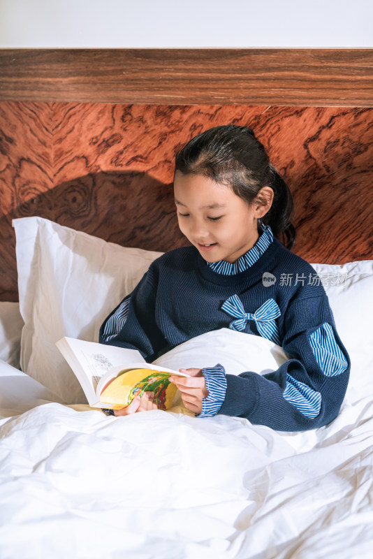 坐在床上认真看书的中国女孩