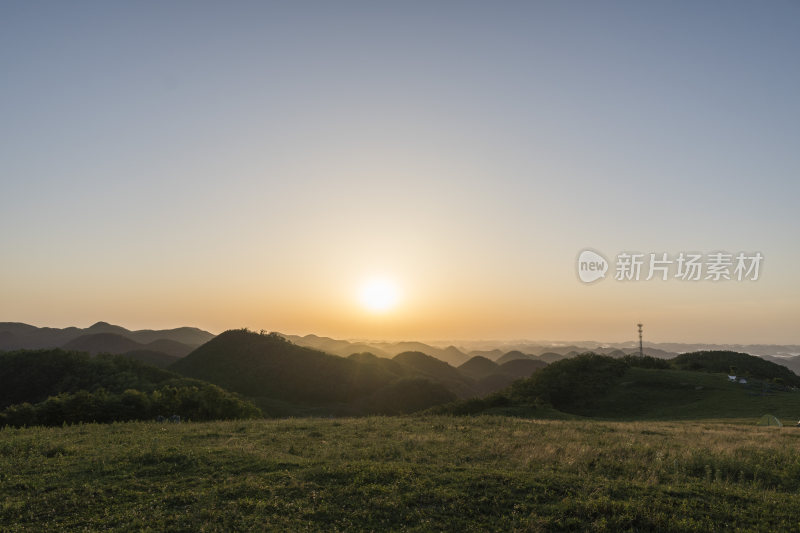 阳光下的广袤草原与起伏山脉的美景