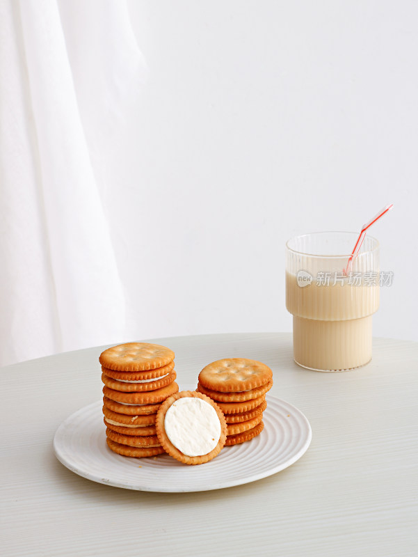 白色桌面上的早餐夹心饼干和牛奶
