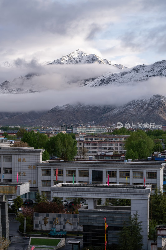 西藏拉萨雪山下的城市建筑高原城市冬日雪景