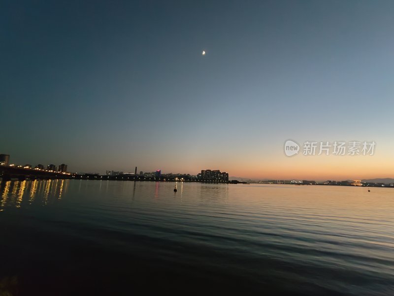 平静江面上映着城市灯火的美丽夜景