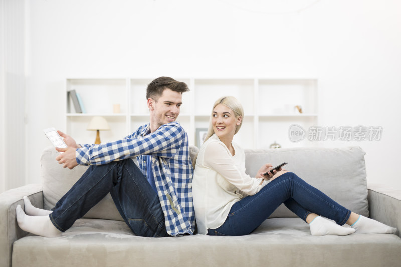 情侣沙发上背对使用电子设备