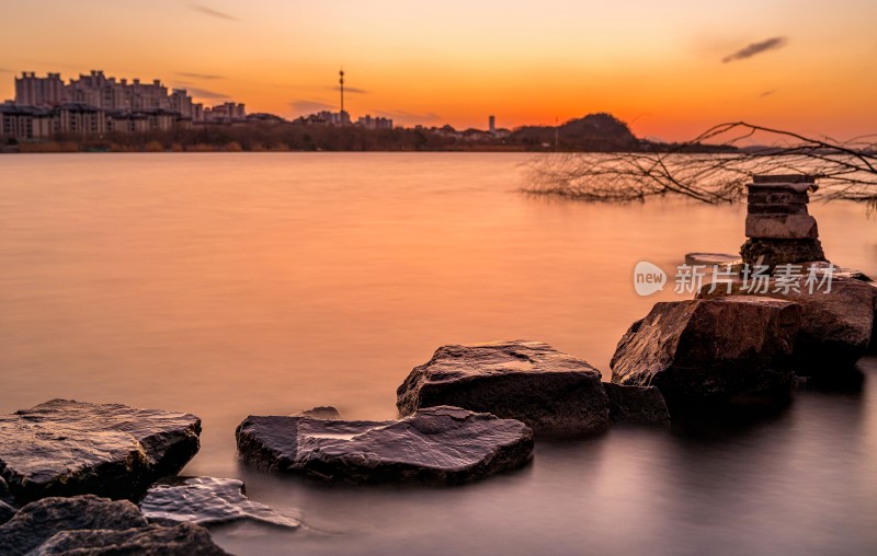 湖边日落景象，芦苇岩石相伴