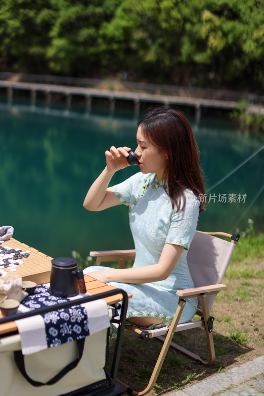 坐在湖边喝茶的美女