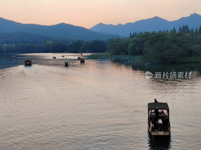 夕阳下的湖面小船与群山相映成趣