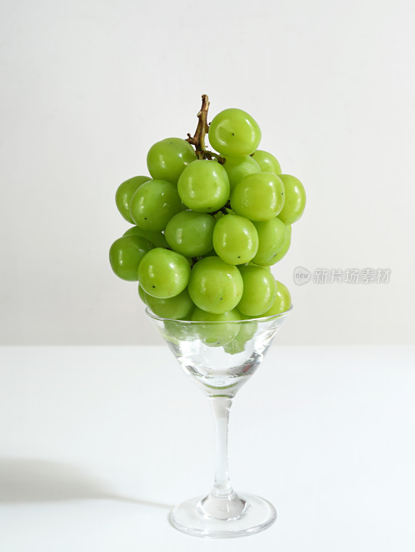 玻璃杯上的一串新鲜水果葡萄