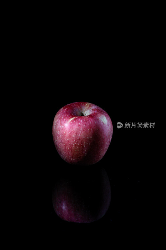 黑色背景上的一个新鲜水果红苹果