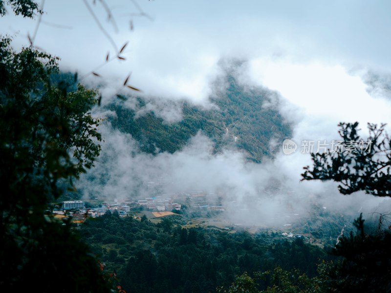 雨崩云雾缭绕中的山间村庄景象