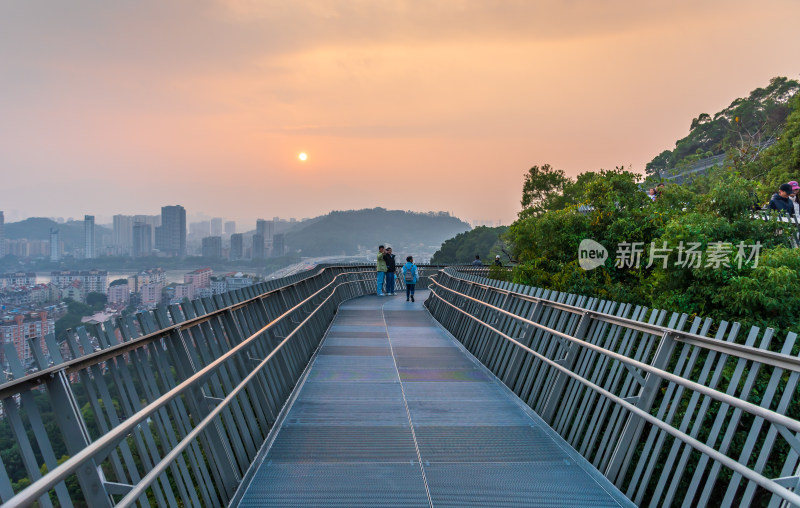 行人漫步观景栈道赏日落