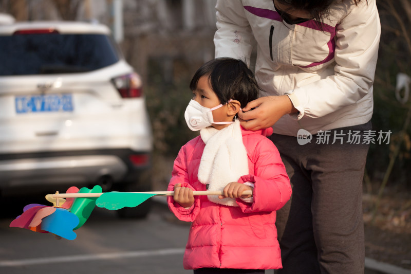 户外妈妈再给女儿整理戴着的口罩