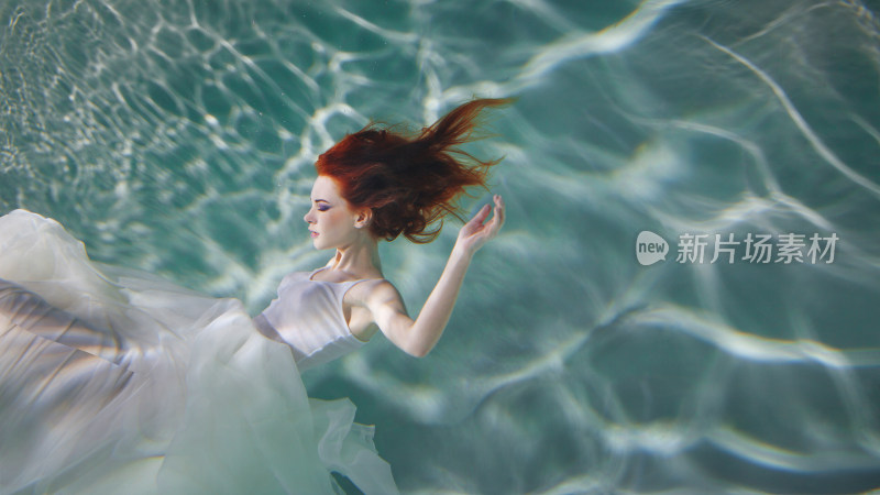 水下红发女子穿白裙漂浮