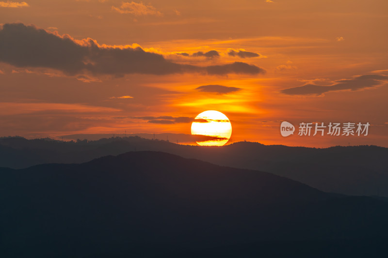 山间日落美景，夕阳映照山脉的景象