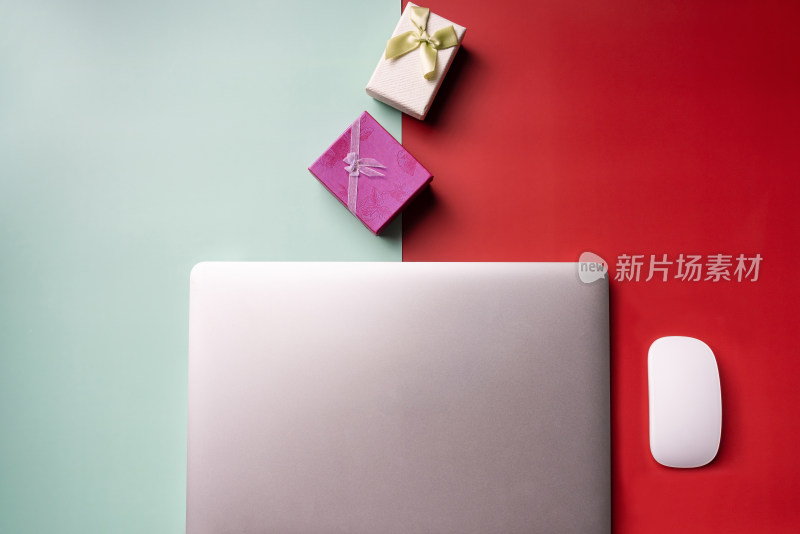 红绿撞色背景上的笔记本电脑和礼物盒