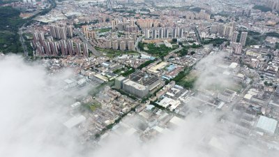 广东东莞：雨后城镇上空云雾缭绕