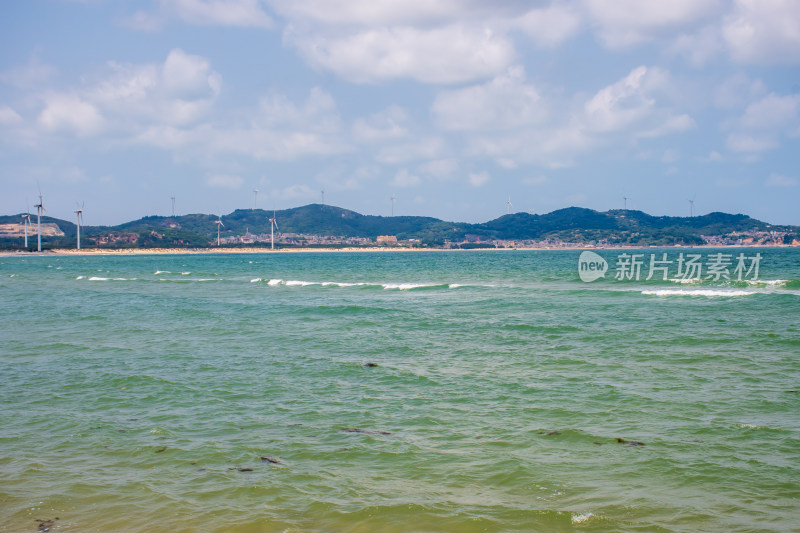 海边远景山峦与风力发电机