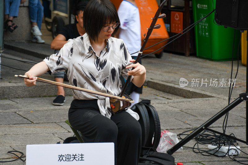 街头女子演奏二胡