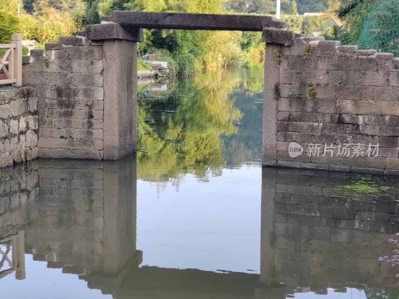 石桥倒映水中的乡村宁静景象