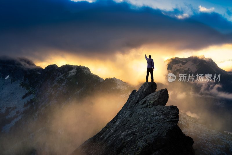 山顶人物高举手臂眺望群山