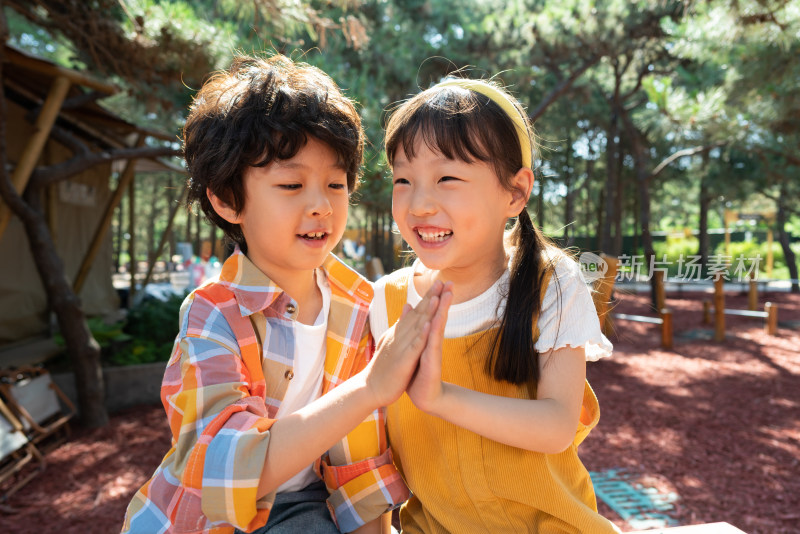 两个小孩子开心击掌庆祝