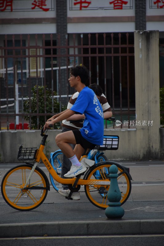 男子骑行黄色共享单车