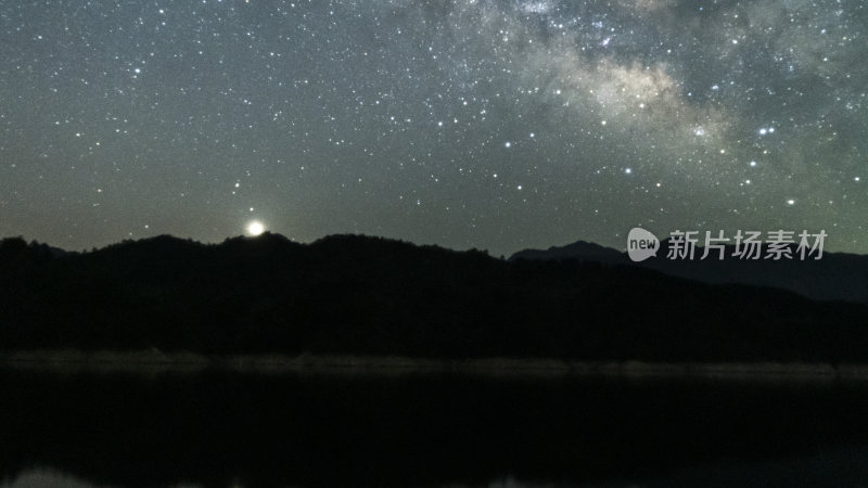 繁星密布的夜空下的山峦与湖水