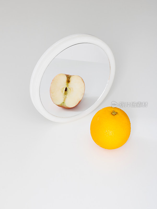 镜子前和镜子中的苹果橙子对比