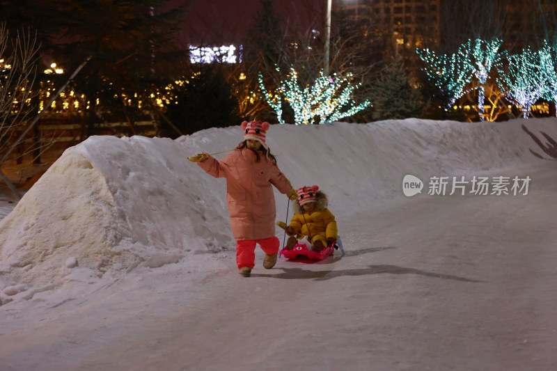 夜晚户外姐妹雪地玩雪橇