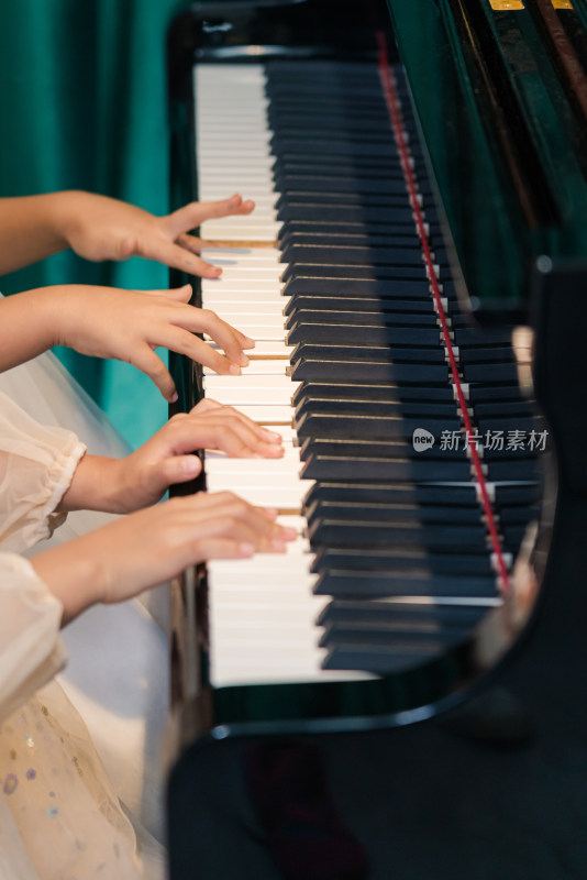 两个弹奏钢琴的女孩手部特写
