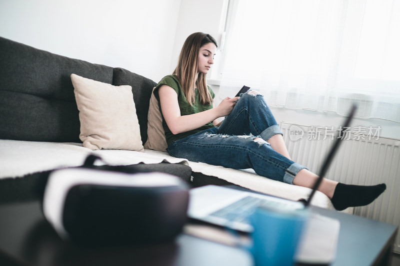 女孩沙发上玩手机休闲场景