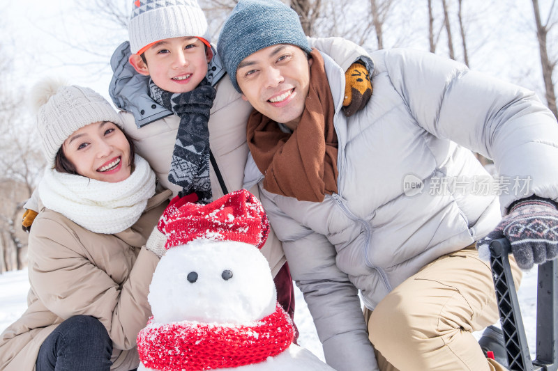 一家三口在雪地里堆雪人