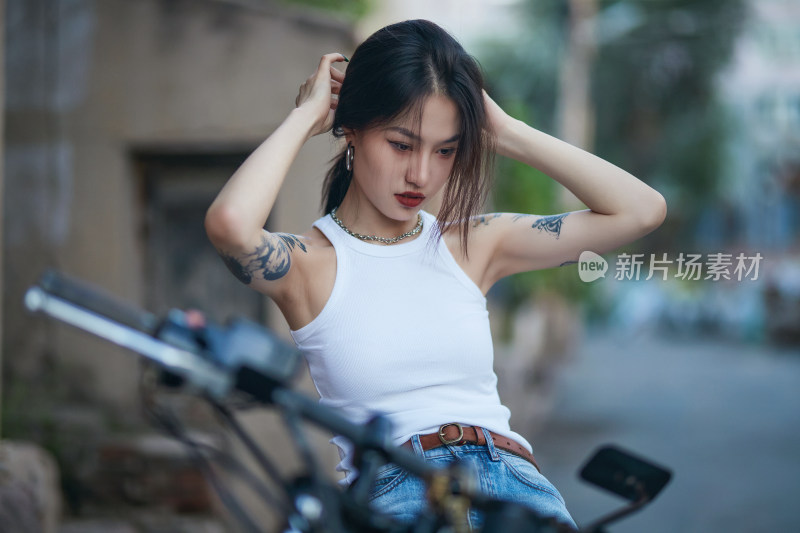 骑在复古摩托车上的时尚亚洲少女