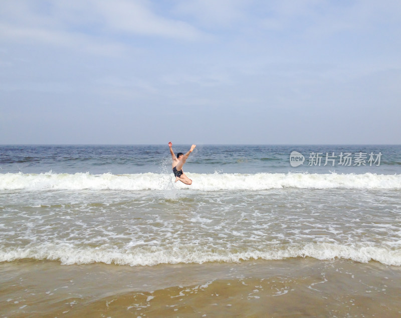 男子在海边跃起