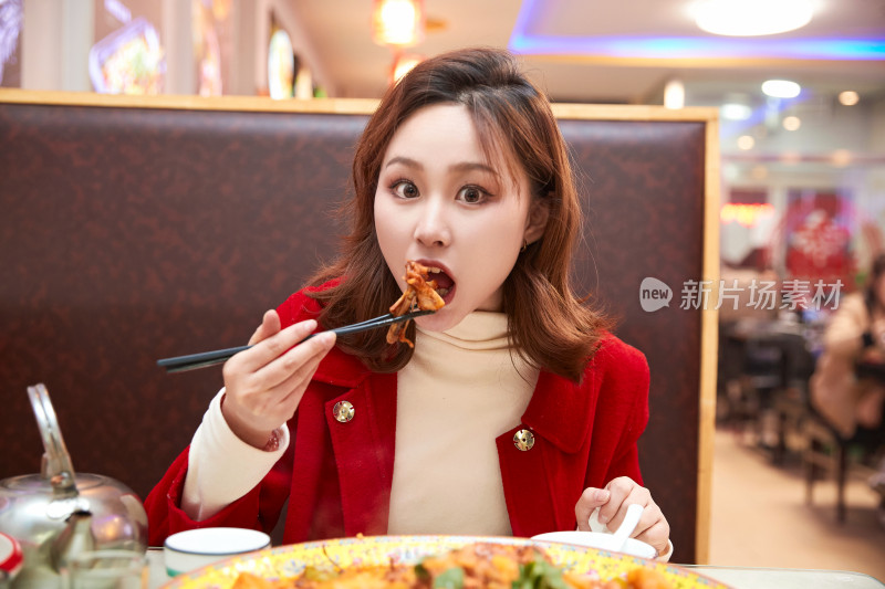 在餐厅吃美味新疆大盘鸡的亚洲少女