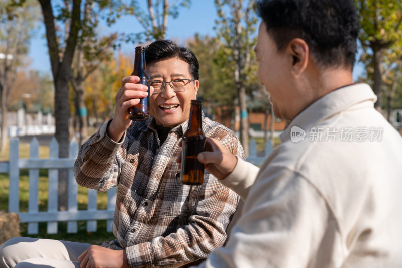 两个老年男人坐在露营地喝啤酒