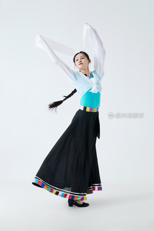 穿着藏族服饰跳着藏族舞蹈的少女