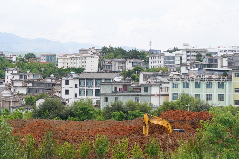 城郊房屋旁挖掘机施工场景