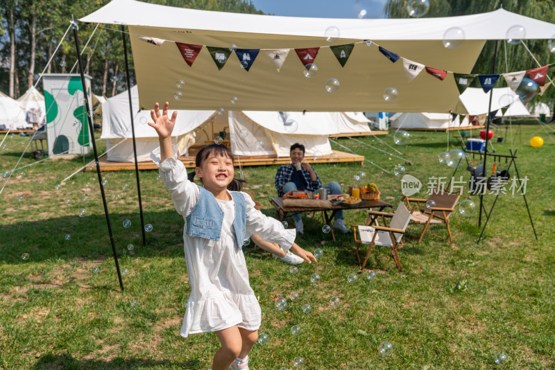 一家人在露营地天幕下玩耍