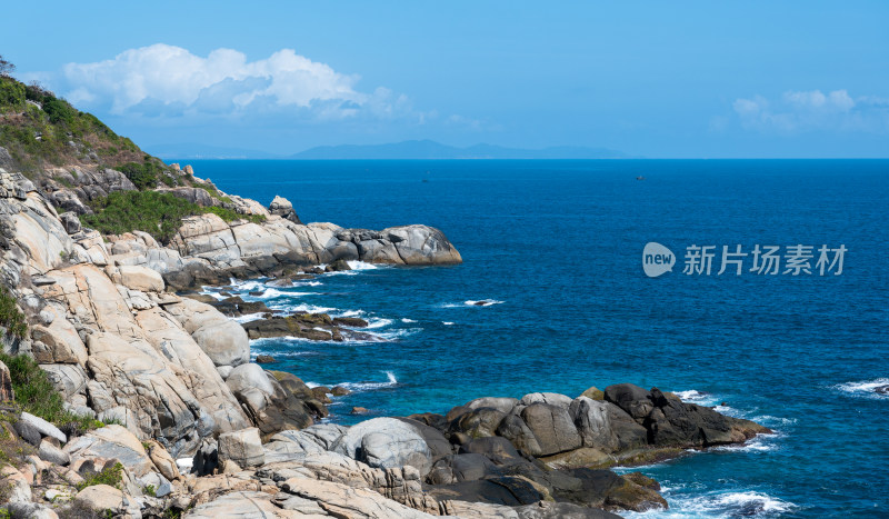 阳光下的海南三亚海岸线上礁石沙滩海浪浪花