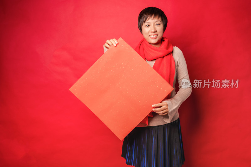 红色背景前拿空白门贴纸的中国女性