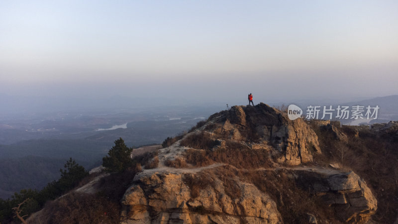 山顶独站一人俯瞰山下壮丽风景