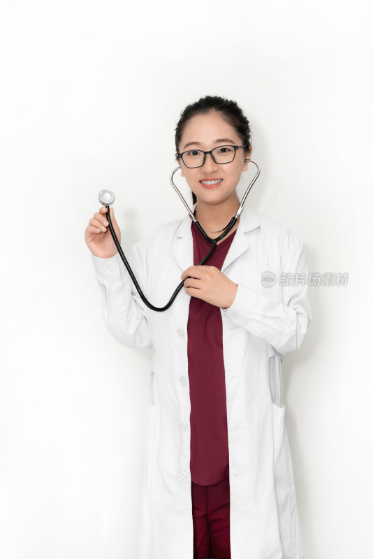 站在白色背景前拿听诊器的中国女性医生
