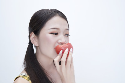 啃咬番茄身穿格子吊带裙的亚洲可爱少女人像