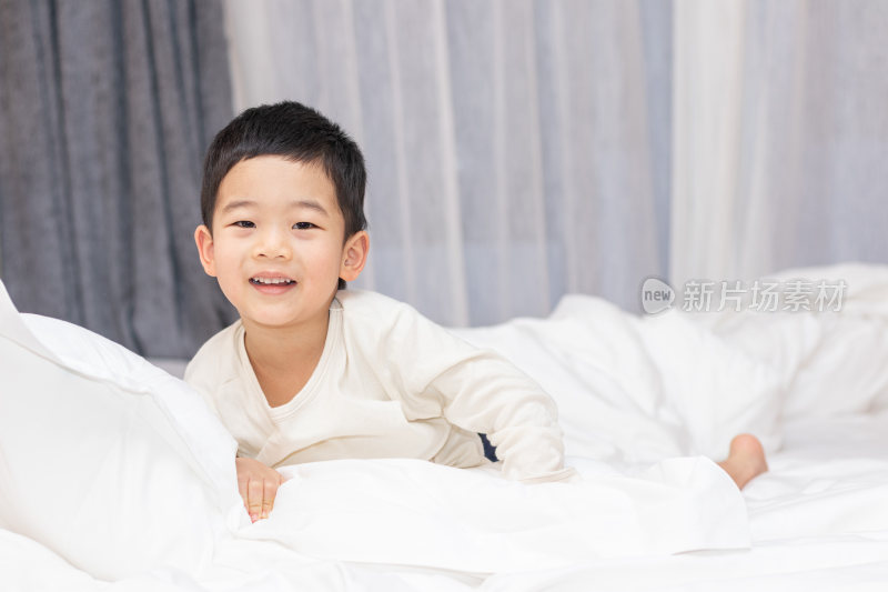 一个小男孩趴在舒适的床上