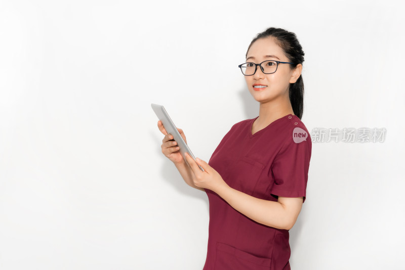 站在白色背景前使用平板电脑的中国女性医生