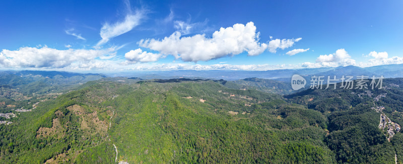 航拍蓝天白云下层峦叠嶂的绿色山脉全景图