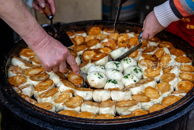 用锅铲翻动生煎包的烹饪场景