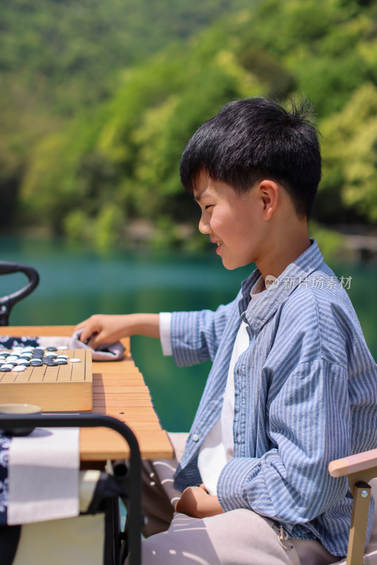 正在野外下棋的中国小男孩