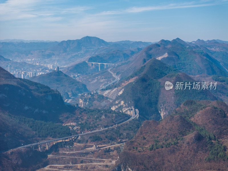 山间城镇全景，高架公路贯穿其中